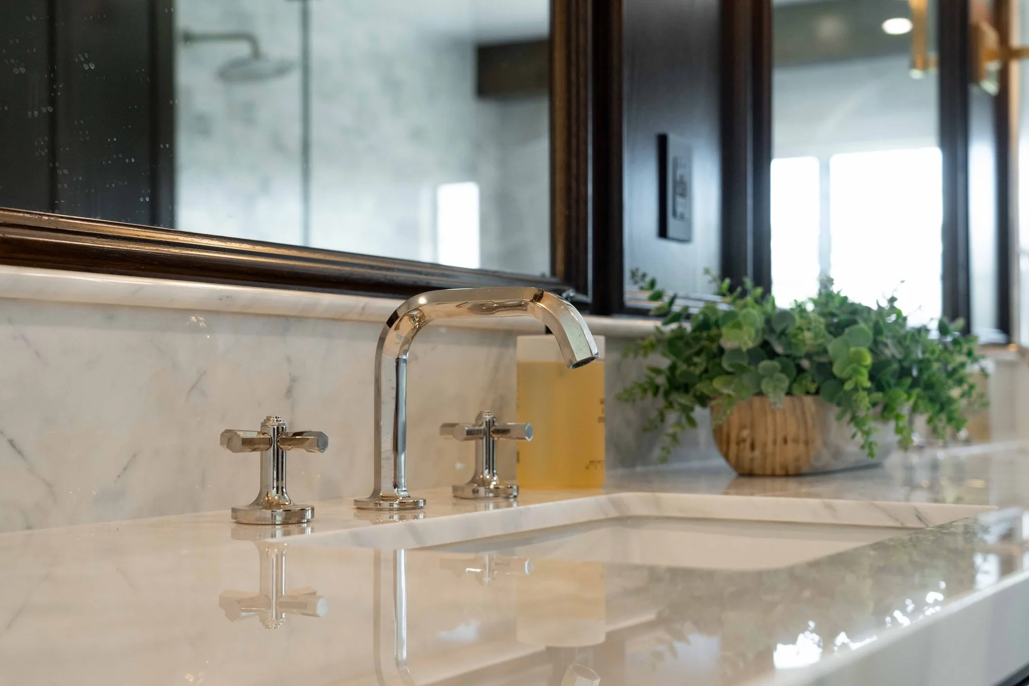 Primary bathroom remodel in La Jolla with dual vanities, custom cabinetry, walk-in shower, and warm natural stone tile by SD Remodel Experts