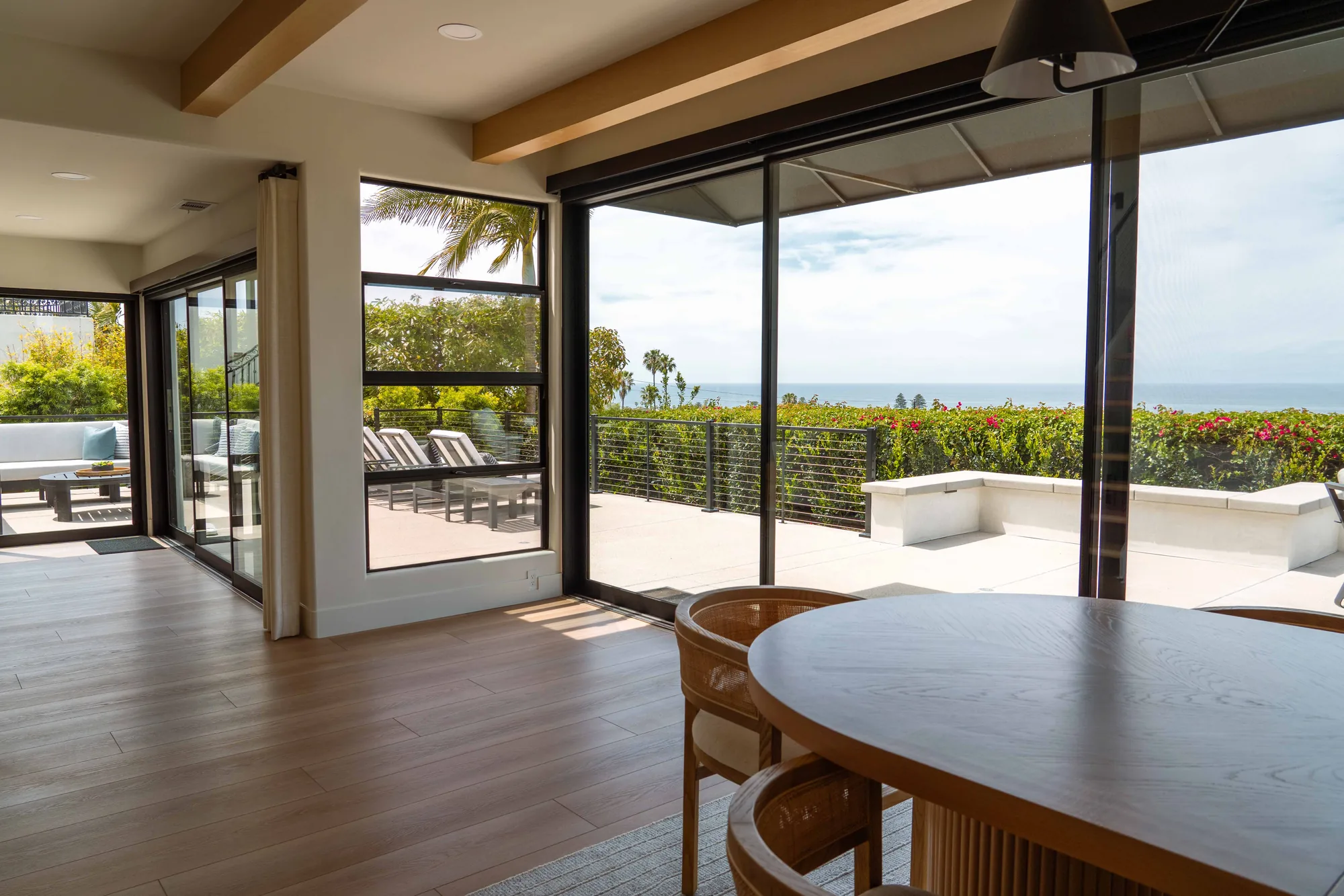 Completed home remodel in Solana Beach with open-concept dining area, floor-to-ceiling sliding glass doors, and panoramic Pacific Ocean views